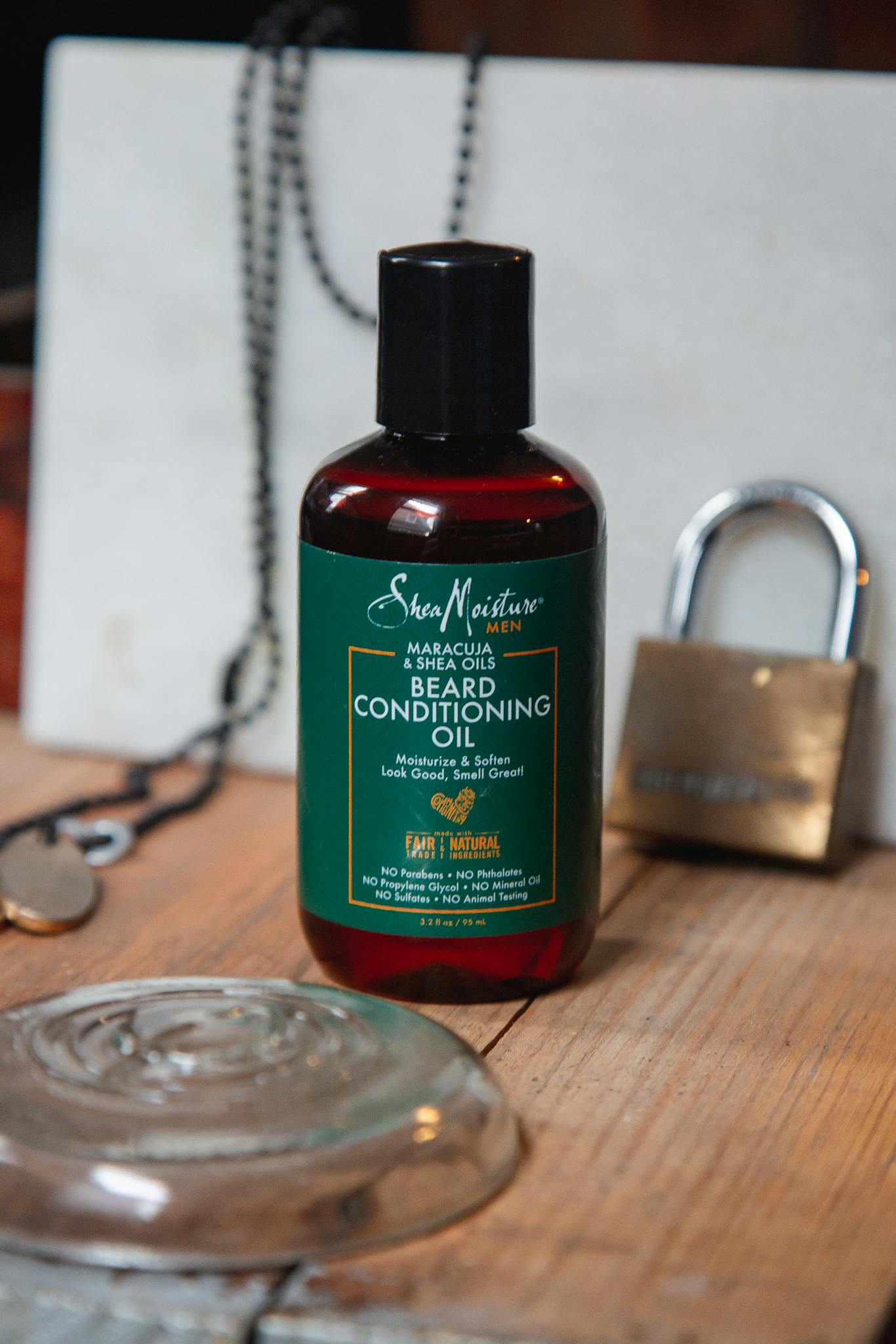 Beard conditioning oil bottle displayed on rustic wooden background.
